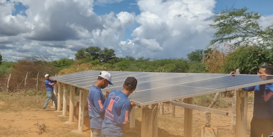 Equipe técnica da Trade Itaparica instalando módulos fotovoltaicos em estrutura de solo na caatinga