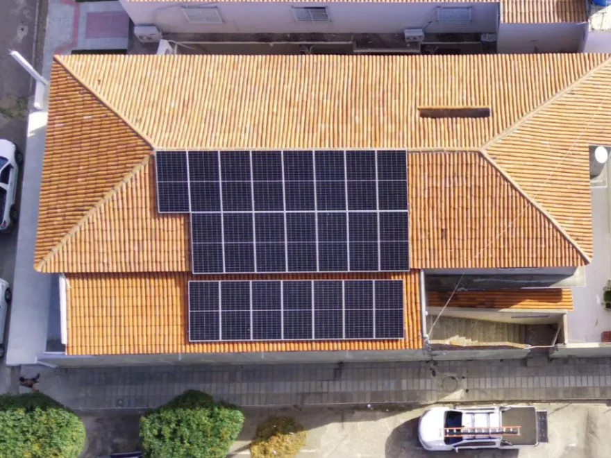 Vista aérea de sobrado no centro urbano com 22 módulos fotovoltaicos instalados sobre o telhado, em Floresta-PE